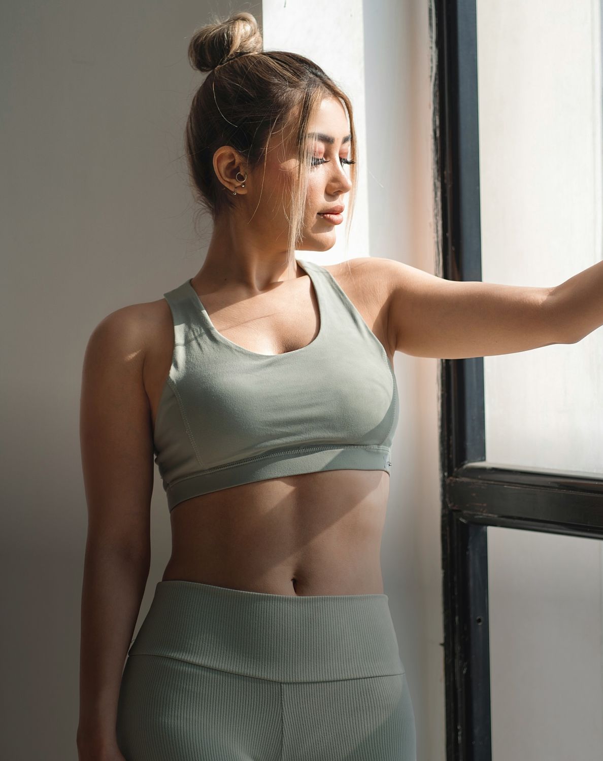 Woman in activewear by a sunlit window