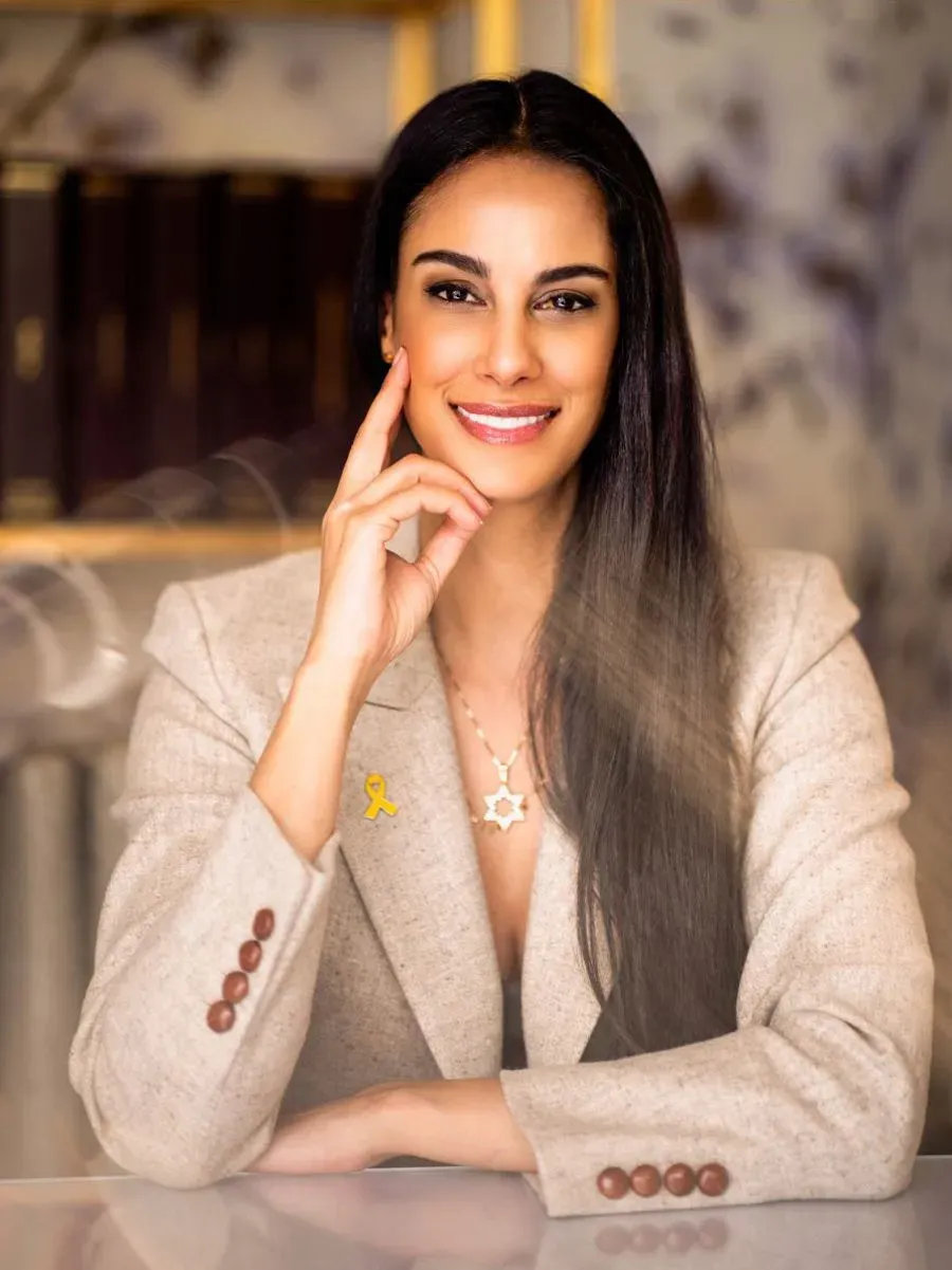 Confident woman smiling in a beige blazer.