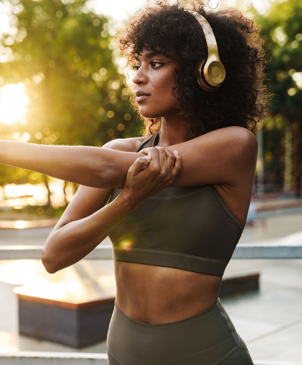 Woman stretching outdoors with headphones on.