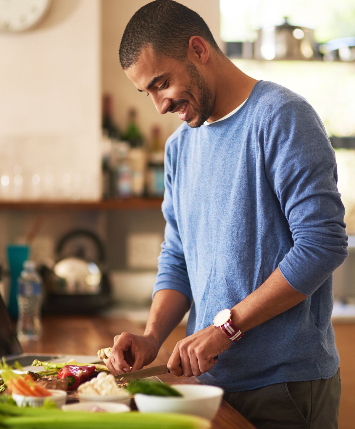 Man chopping vegetables in a cozy kitchen.