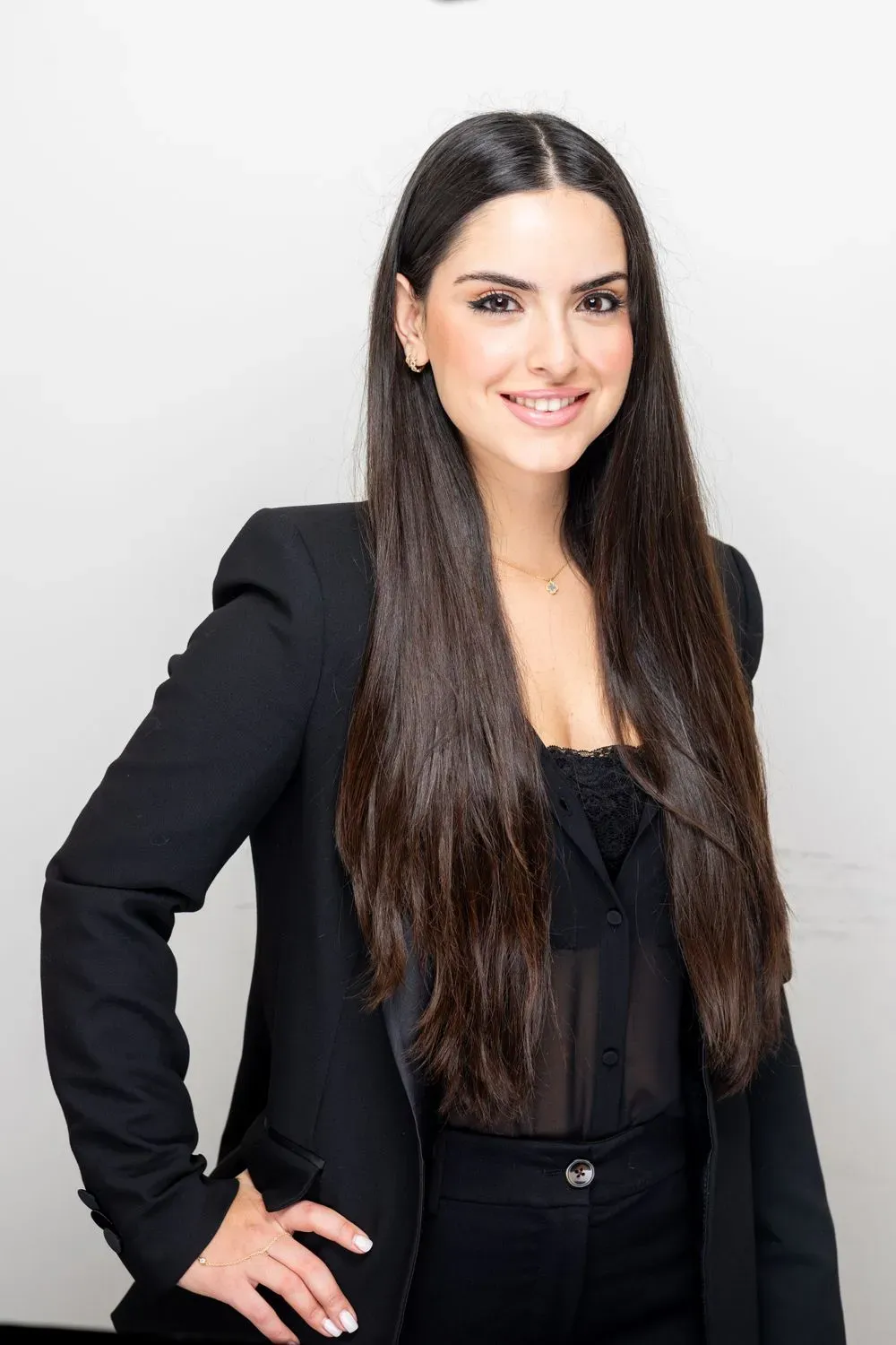Professional woman in black blazer smiling confidently.