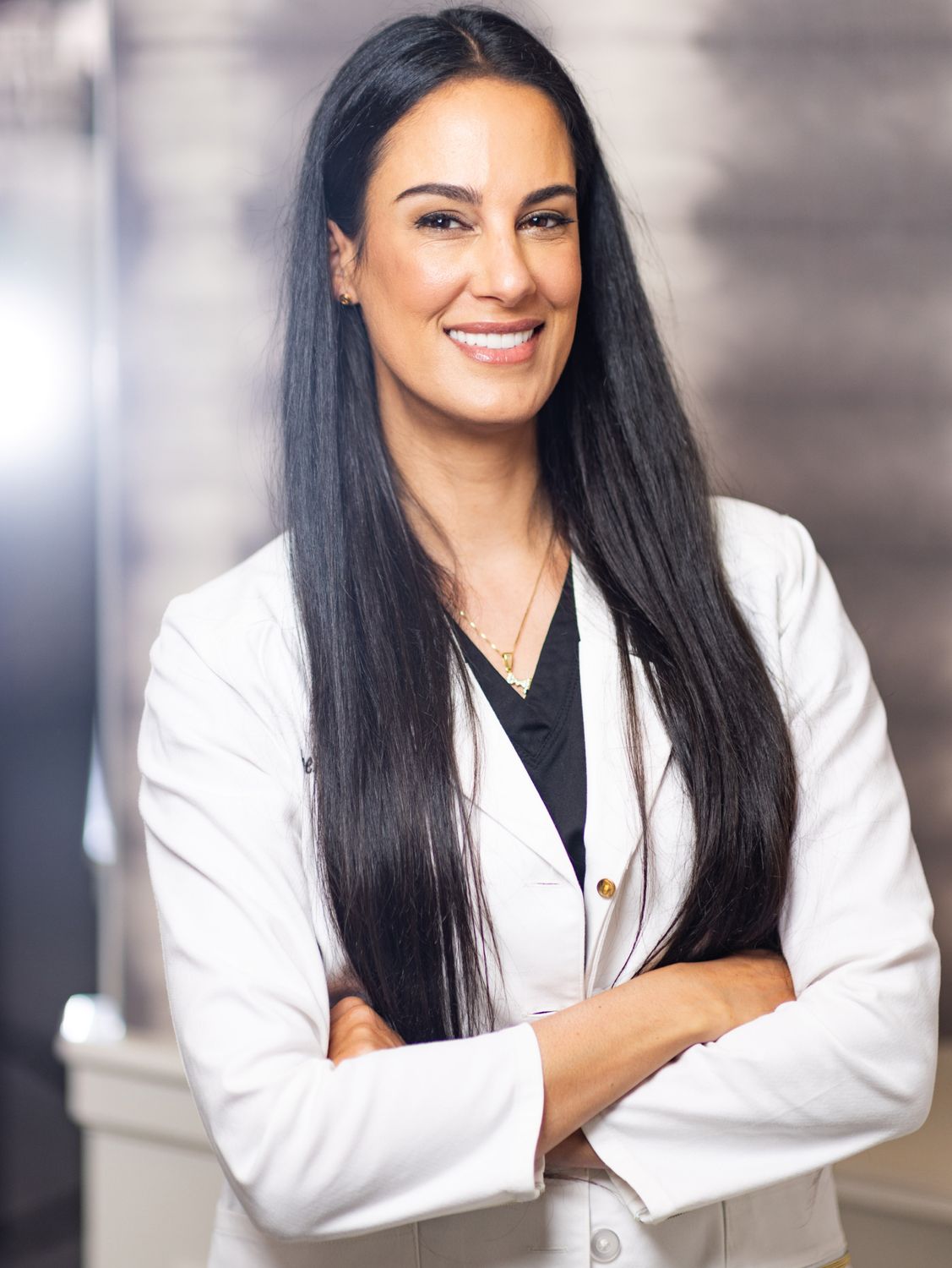 Smiling professional woman in a white lab coat.