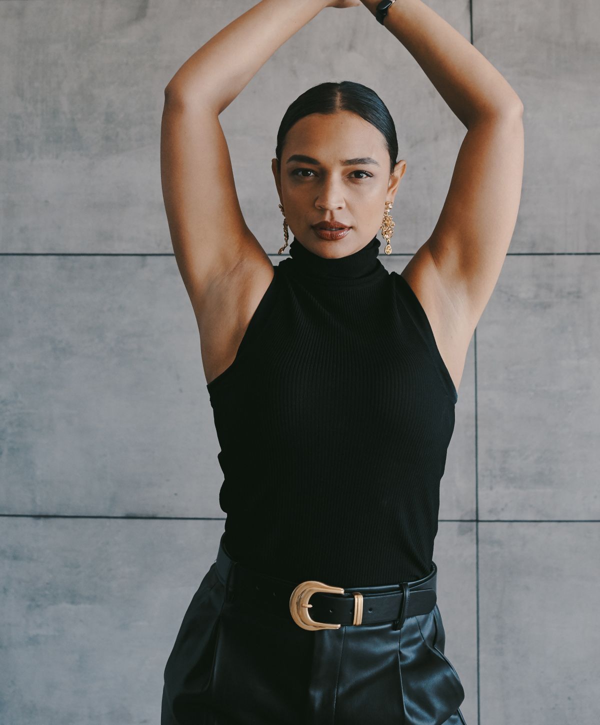 Woman posing confidently in black outfit.