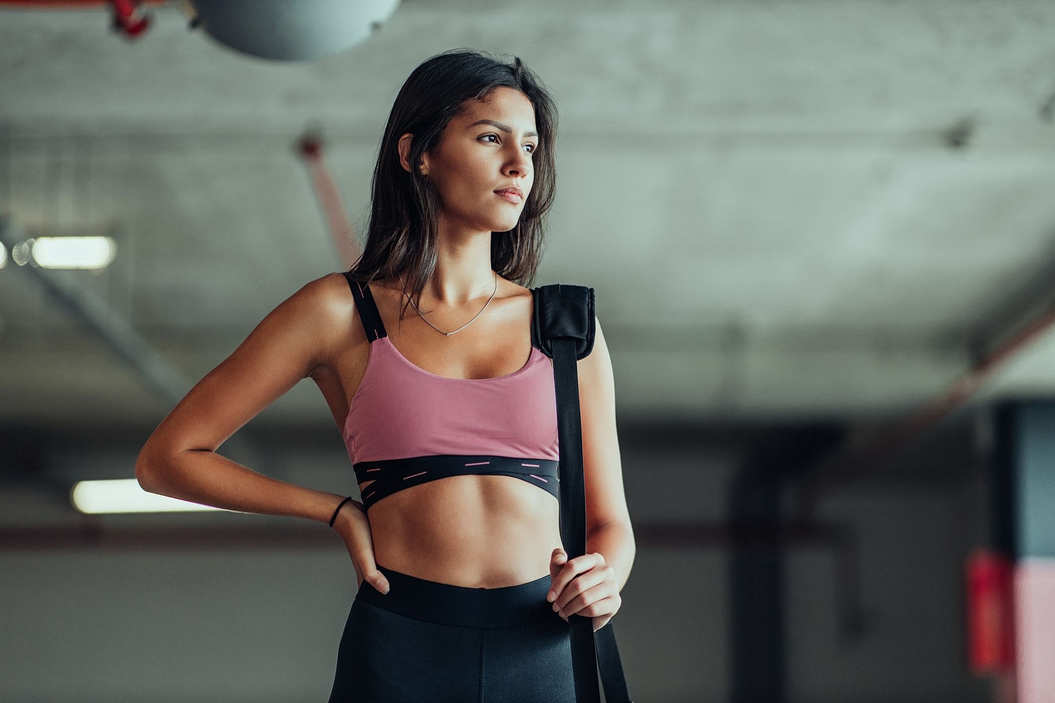 Woman in athletic wear, standing confidently indoors.