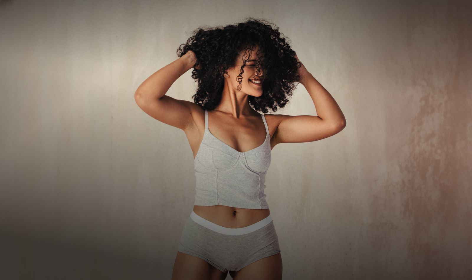 Woman smiling and playing with her curly hair