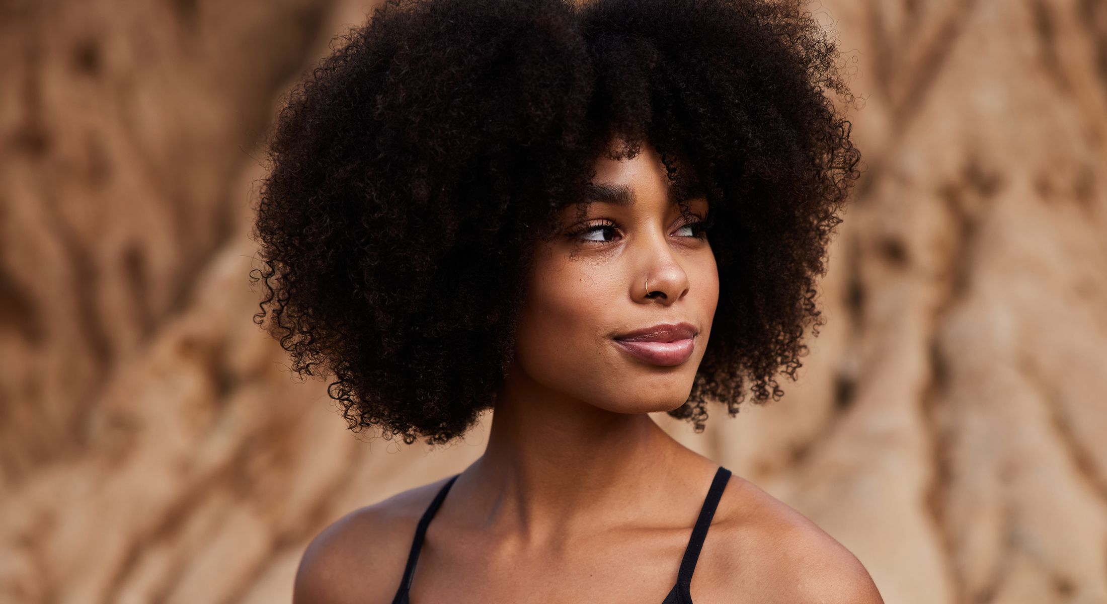 Woman with curly hair and serene expression.